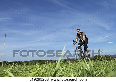 Man cycling in the country View Large Photo Image Stock Image - Man cycling in the country. Fotosearch