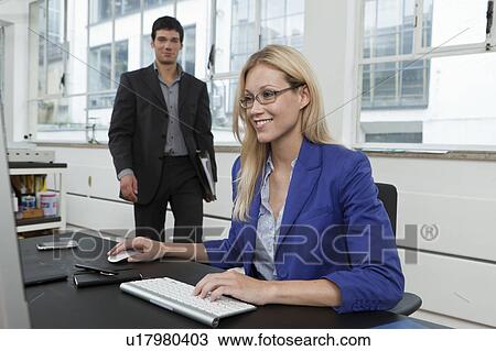 Stock Image - Man delivering file to boss. Fotosearch