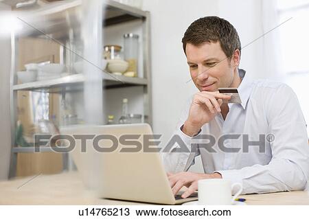 Stock Image - Man doing online shopping. Fotosearch