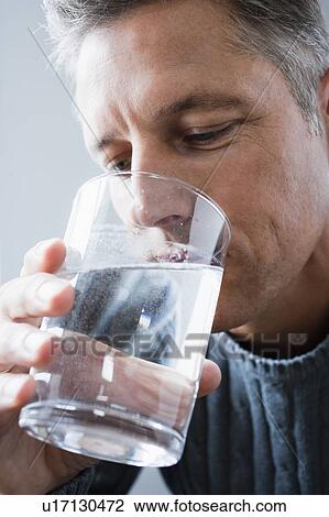 Stock Image - Man drinking medicine. Fotosearch