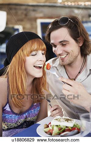 Stock Photo - Man feeding woman with tomatoes. Fotosearch