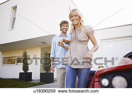 Man helping his wife out of electric car View Large Photo Image Stock Photo - Man helping his wife out of electric car. Fotosearch