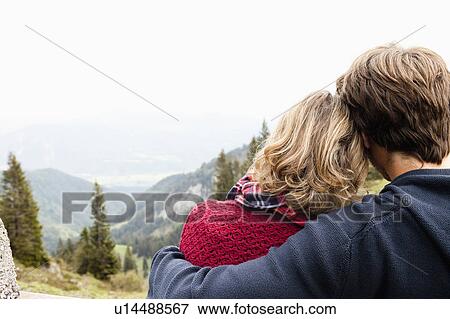 Man hugging woman watching landscape View Large Photo Image Stock Photo - Man hugging woman watching landscape. Fotosearch