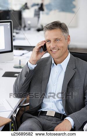 Stock Image - Man in office phoning. Fotosearch