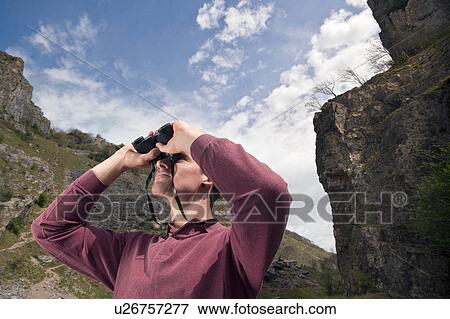 Man in valley with binoculars View Large Photo Image Stock Photo - Man in valley with binoculars. Fotosearch