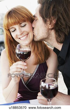 Stock Image - Man kissing woman on cheek. Fotosearch