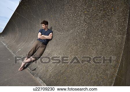 Man leaning on curved wall View Large Photo Image Stock Image - Man leaning on curved wall. Fotosearch