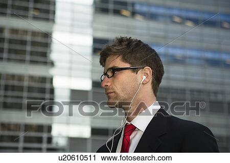 Man listening to headphones in city View Large Photo Image Stock Image - Man listening to headphones in city. Fotosearch