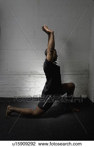 Stock Image - Man lunging in gym. Fotosearch