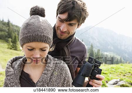 Man offering woman binocular View Large Photo Image Stock Image - Man offering woman binocular. Fotosearch