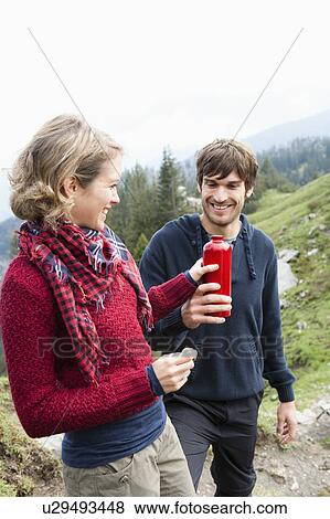 Stock Photo - Man offering woman bottle. Fotosearch