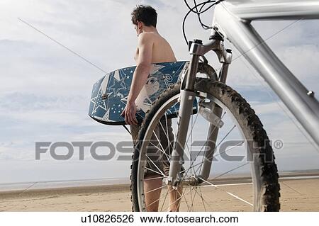 Man on beach with bike and boogie board View Large Photo Image Stock Photograph - Man on beach with bike and boogie board. Fotosearch