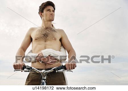 Stock Image - Man on bike with woman holding behind. Fotosearch