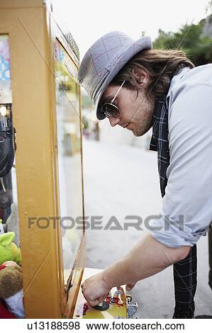 Man playing on arcade cabinet View Large Photo Image Stock Photo - Man playing on arcade cabinet. Fotosearch
