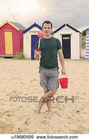 Stock Photo - Man prepares for fun on beach. Fotosearch