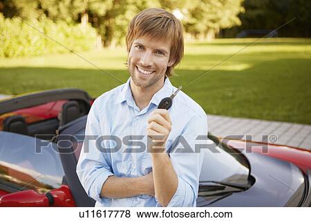 Stock Photo - Man proudly showing his key to his car. Fotosearch