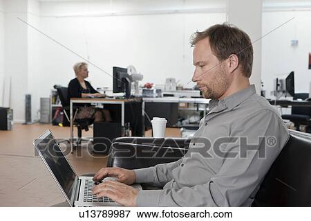 Man relaxing on sofa with laptop View Large Photo Image Stock Photo - Man relaxing on sofa with laptop. Fotosearch