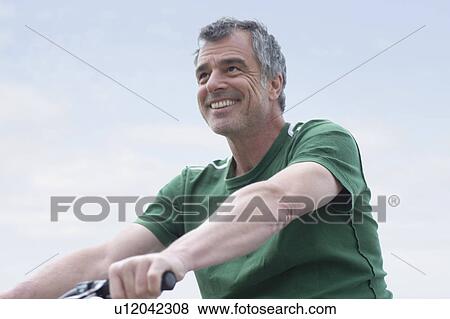 Stock Photo - Man riding bike. Fotosearch