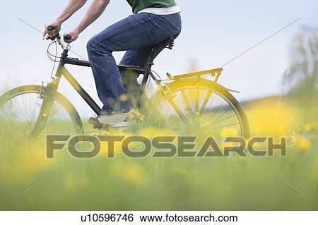 Stock Photograph - Man riding bike. Fotosearch
