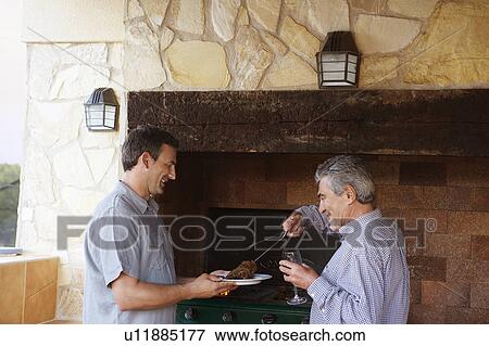 Man serving up meat from barbeque View Large Photo Image Stock Photo - Man serving up meat from barbeque. Fotosearch