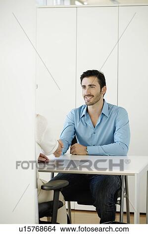 Man shaking hands in office View Large Photo Image Picture - Man shaking hands in office. Fotosearch