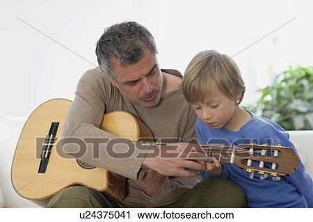 Man showing son guitar View Large Photo Image Stock Image - Man showing son guitar. Fotosearch