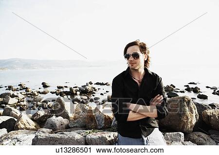 Stock Image - Man sitting in front sea. Fotosearch