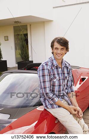 Man sitting proudly on his electric car View Large Photo Image Stock Photograph - Man sitting proudly on his electric car. Fotosearch