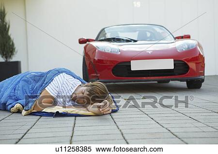 Man sleeping next to his electric car View Large Photo Image Stock Photography - Man sleeping next to his electric car. Fotosearch