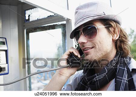 Stock Photograph - Man speaking at call box. Fotosearch