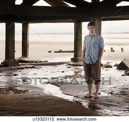 Man standing by stream on beach View Large Photo Image Stock Image - Man standing by stream on beach. Fotosearch