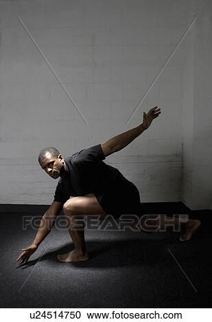 Stock Image - Man stretching in gym. Fotosearch