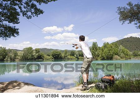 Picture - Man trying to catch a fisch. Fotosearch