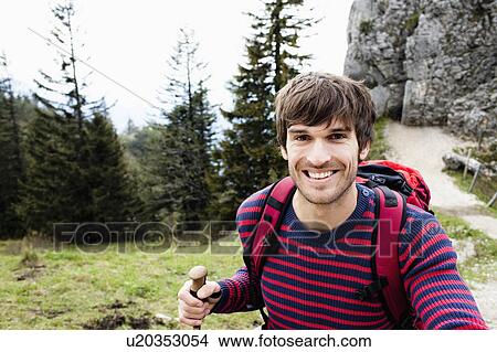 Picture - Man walking on mountain trail. Fotosearch