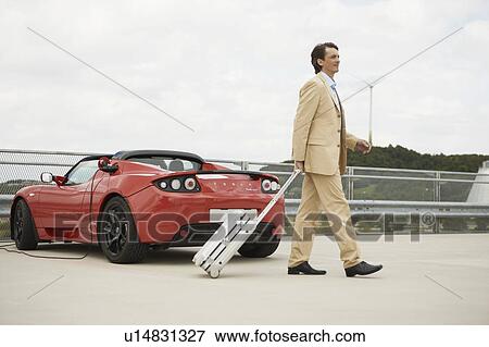 Man walking with trolley, electric car View Large Photo Image Stock Photo - Man walking with trolley, electric car. Fotosearch