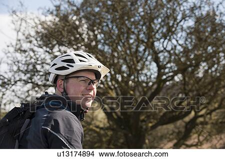 Man wearing bike helmet in countryside View Large Photo Image Picture - Man wearing bike helmet in countryside. Fotosearch