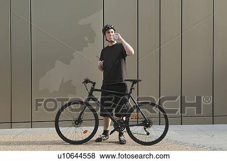 Man with bicycle drinking water View Large Photo Image Stock Photo - Man with bicycle drinking water. Fotosearch