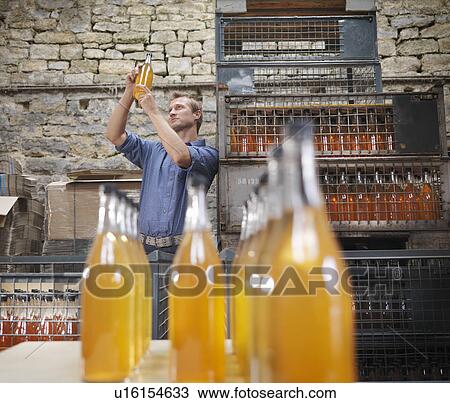 Stock Image - Man with bottle of organic cider. Fotosearch
