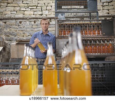 Stock Photo - Man with bottles of organic cider. Fotosearch