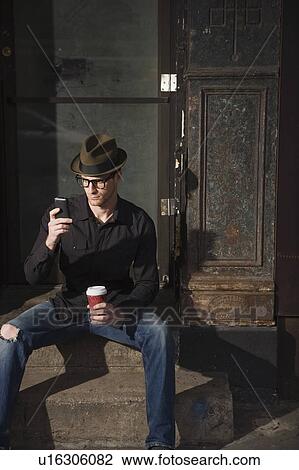 Stock Image - Man with coffee and a cell phone. Fotosearch