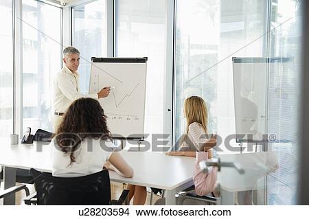 Man with flip-chart in office meeting View Large Photo Image Picture - Man with flip-chart in office meeting. Fotosearch