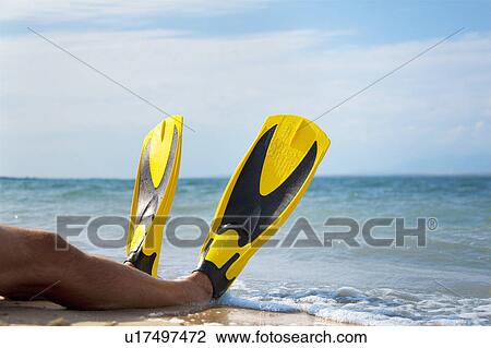 Stock Image - Man with flippers at the beach. Fotosearch
