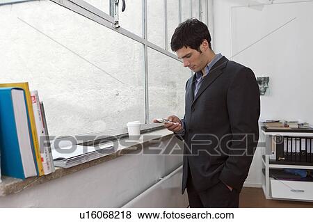 Stock Photo - Man writing a text on his phone. Fotosearch