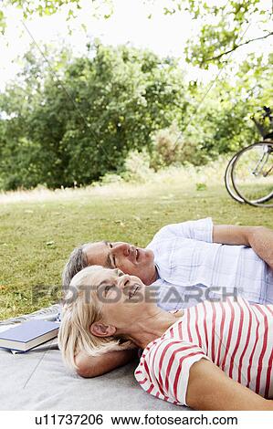 Mature couple cuddling on picnic blanket View Large Photo Image Stock Photograph - Mature couple cuddling on picnic blanket. Fotosearch