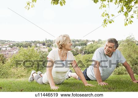 Mature couple doing push ups in park View Large Photo Image Stock Photo - Mature couple doing push ups in park. Fotosearch