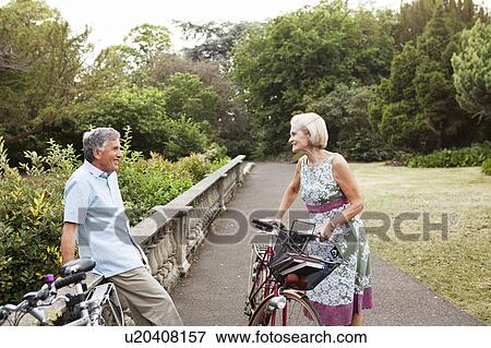Stock Photo - Mature couple having cycling break. Fotosearch