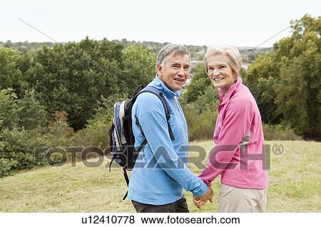 Stock Photo - Mature couple hiking, looking back. Fotosearch