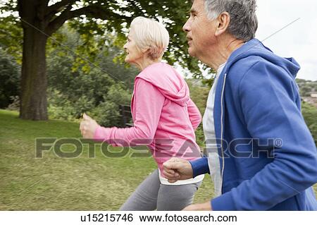Mature couple jogging in park View Large Photo Image Stock Photograph - Mature couple jogging in park. Fotosearch