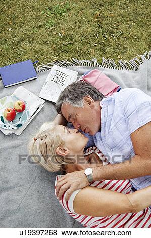 Mature couple kissing on picnicblanket View Large Photo Image Stock Photo - Mature couple kissing on picnicblanket. Fotosearch