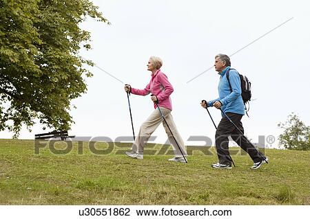 Mature couple nordic walking in park View Large Photo Image Stock Image - Mature couple nordic walking in park. Fotosearch